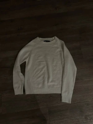 Vit stickad tröja från Vero Moda - Mysig vit stickad tröja från Vero Moda i storlek S. Tröjan har rund halsringning, ribbade muddar vid ärmslut och nederkant samt lång ärm. Perfekt för lager på lager under kyliga dagar.