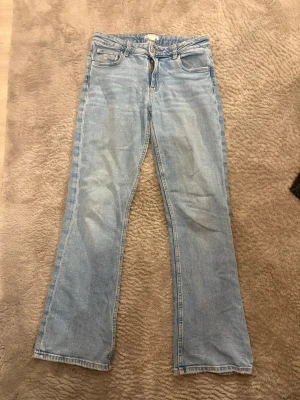 Ljusblå bootcut jeans Gina Tricot - Säljer ett par ljusblå jeans från Gina Tricot i storlek 158. Jeansen har klassisk femficksdesign, bootcut-ben och normal midja. Materialet är mjukt denim i bomull och de har en snygg tvättad look. Perfekta till sneakers eller boots!