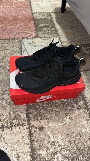 Svarta Nike Presto sneakers - Säljer ett par helsvarta Nike Presto sneakers med snygg, sportig design. Skorna har mesh-ovandel, snörning och en mjuk, flexibel sula som ger grym komfort. Perfekta för dig som gillar stilrena och bekväma sneakers till vardags.