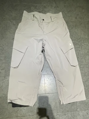 Gråa rihno pants från Harlaut, S - Säljer ett par gråa cargopants från Harlaut i storlek S. Byxorna har bred passform, stora fickor på sidorna och klassisk cargostil. De har bälteshällor och knappstängning i midjan. Små repor men syns knappt.