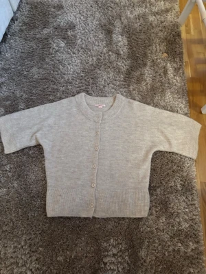 Beige kofta från Gina Tricot - Mysig beige kofta från Gina Tricot i storlek M. Koftan är stickad med ribbade muddar och har knappar framtill. Aldrig använd, skriv för fler frågor eller bilder🤍