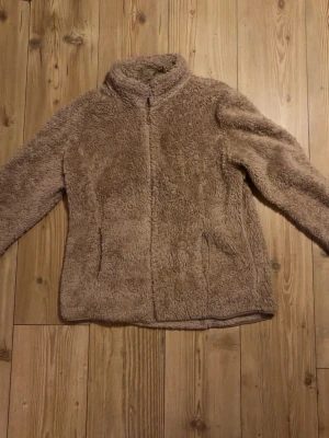 Beige teddyjacka från Mywear Woman - M fn beige teddyjacka från Mywear Woman Outerwear Collection autumn vibes. Jackan har hög krage, dragkedja framtill och två fickor. Supermjuk och fluffig med en loose fit som är perfekt för kyliga dagar.