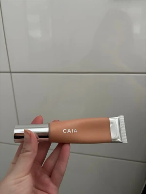 CAIA Bare Glow Skin Tint Foundation - Perfekta hudtonen med CAIA Bare Glow Skin Tint, en foundation i beige nyans. Kommer i en smidig tub med silvrig kork och detaljer. Innehåller 30 ml och ger en naturlig glow till huden. Perfekt för dig som vill ha en lätt och fräsch bas. Nyans 30