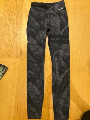  Mönstrade leggings från Stronger i XS - Snygga leggings från Stronger i storlek XS med bladliknande mönster. Dem är stretchiga och bekväma. Perfekta för träning. Nytt skick. 