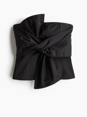 Svart bandeau topp med stor rosett - Säljer en svart bandeau topp från Hm med en stor, dramatisk rosett framtill. Toppen är axelbandslös och har en snygg, figurnära passform. Materialet är slätt och har en lätt glans. Dragkedja baktill för enkel påklädning. Liten i storlek mer som en storlek S!  Prislapp kvar och säljs inte längre🥰