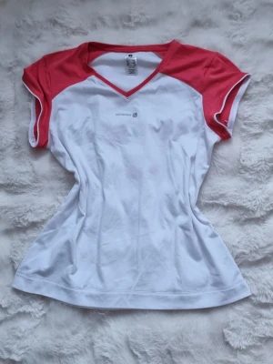 Tränings t-shirt  - En vit träningströja men rosa detaljer, väldigt luftig och skön mot kroppen.