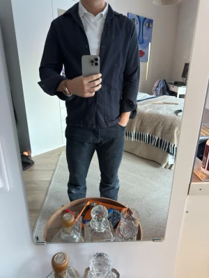 Mörkblå overshirt från Riley - Säljer en stilren mörkblå overshirt från Riley i storlek S. Jackan har klassisk krage. Tillverkad i ett slitstarkt bomullstyg som passar perfekt till lager-på-lager. Enkel och clean look som funkar till allt.