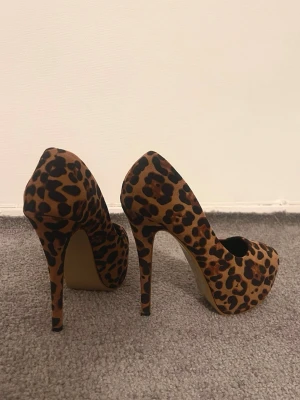 Leopardmönstrade pumps med hög klack - Säljer ett par snygga pumps med leopardmönster och riktigt hög klack. Skorna har en rund tå och är täckta i ett mjukt material som ger en cool och trendig vibe. Perfekt för dig som vill sticka ut med din stil. Oanvända.
