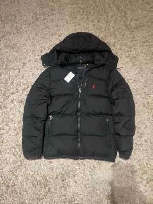 Polo ralph lauren puffer jacka vinter herr M svart dun  - Polo Ralph lauren puffer  i storlek M. Mycket bra skick inga skador eller defekter. Äkta, bevis finns. Skriv vid frågor och funderingar. Postas samma dag som köp eller dagen därpå🙌💯