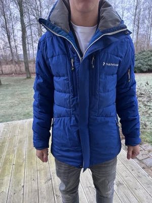 Blå Peak Performance pufferjacka M - Säljer nu min peak performance jacka som är i väldigt fint skick. Perfekt till dig som ska ut och åka skidor eller för en kall vinterdag! Modellen är 176 och 65kg. Endast avvänd ett par gånger och inga defekter. Hör av dig vid funderingar🙌 