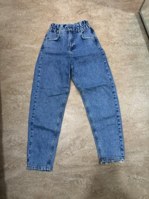 Blå jeans  - Ett par jeans från Gina Tricot i stl 34 som är i väldigt bra skick säljs för 100 kr. 
