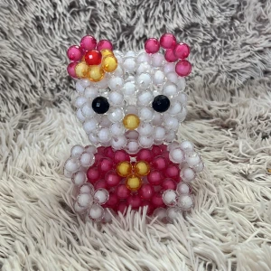 Pärl Hello Kitty figur i vitt och rosa  - Söt Hello Kitty figur gjord av pärlor i vitt och rosa med detaljer i gult och svart. Perfekt för dig som älskar Hello Kitty 