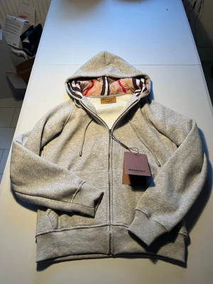 Grå burberry zip hoodie  - Grå burberry zip hoodie i storlek M men sitter som storlek S. Den är i nytt skick. Hör av er vid intresse eller frågor. 