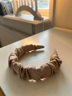 Beige Diadem - Diadem i beige färg med ett rynkat satin tyg. Mycket bra skick!