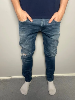 Replay Anbass blå jeans - Säljer ett par Replay Anbass jeans i blå tvätt med snygga slitningar. Mycket bra skick, inga hål. Skickar snabbt efter att du har beställt. Frågor? Skicka ett meddelande👍