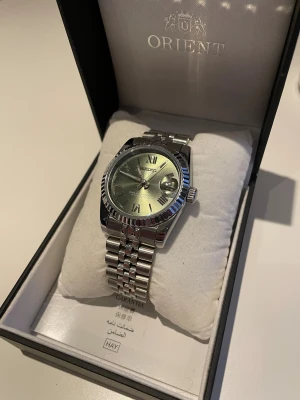 Olive Green Date-just Seiko Mod - Seiko Mod with a fluted Date-just case and a jubilee bracelet design. Olive green dial with roman numerals and an open case back. Comes with extra links incase resizing is necessary!! Watch bor is not included in the order!!