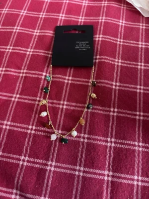 Guldarmband med färgglada pärlor från Pilgrim - Säljer ett tunt guldarmband med små pärlor och stenar i olika färger från pilgrim. Jättefint och aldrig använts. Expanderbar kedja.