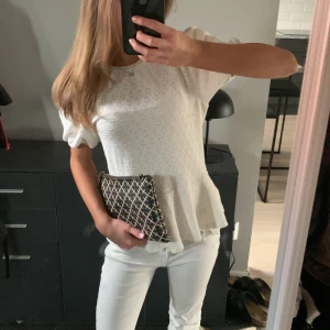 Söt topp/blus med volang 🤍 - Supersöt vit blus med diskret hålmönster, puffärmar och volang nertill. Blusen har rund halsringning med liten spetskant och är i mjuk bomull. Perfekt för dig som gillar romantisk och feminin stil. Jätte fint skick 🤍storlek XS. 