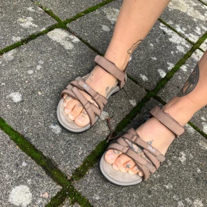 Fina sandaler från Teva ”Tirra Leather Caribou” - Fina sandaler från Teva, sköna och bekväma att gå i både inne i stan och ute på äventyr. Funkar bra lite överallt! Knappt använda pga fel storlek. Inköpta för 1299 kr nu under sommaren. Priset går att diskutera :)