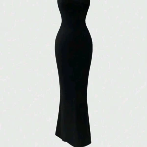 Svart långklänning med tight passform - Snygg svart långklänning med figurnära siluett och ärmlös design. Klänningen har en enkel och stilren look, perfekt för dig som gillar minimalistisk stil. Materialet är mjukt och stretchigt, vilket gör att den sitter bekvämt och framhäver formerna.