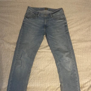 Ljusblå raka jeans från Lee - Snygga ljusblå jeans från Lee med klassisk femficksdesign och raka ben. Jeansen har Lee-logga på bakfickan och läderpatch i midjan. Perfekt passform och tidlös stil, tillverkade i slitstarkt denimtyg.
