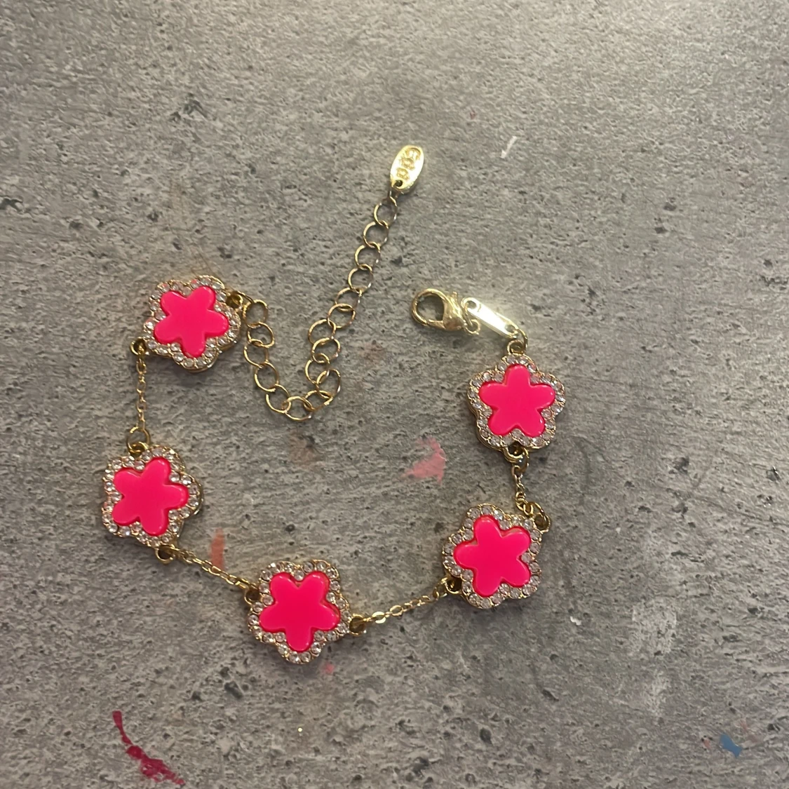 Guldarmband med rosa blommor