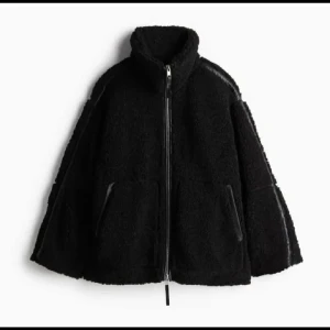 Svart teddyjacka med dragkedja - Virala teddyjackan från HM. Mysig svart teddyjacka med hög krage och hel dragkedja framtill. Jackan har två fickor med dragkedja och en oversized passform.