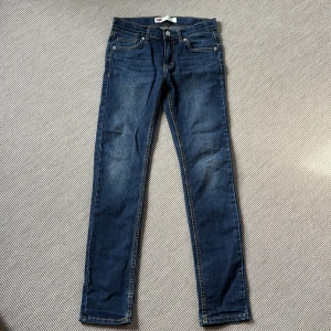 Levi's 510 Skinny jeans blå - Säljer ett par klassiska Levi's 510 Skinny jeans i mörkblå denim. De har smal passform, fem fickor och snygga kontrastsömmar. Perfekta för dig som gillar en tajt look och vill ha ett par stilrena jeans med ikonisk Levi's-detalj på bakfickan.