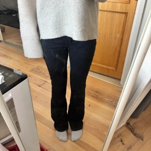 Svarta bootcut jeans från bik bok - Snygga svarta jeans med bootcut-modell. Jeansen har en mörk tvätt och sitter tajt över låren för att sedan släppa ut vid bensluten. Perfekta för dig som gillar en tidlös och trendig look.