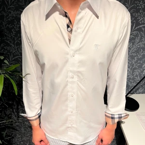 Vit Burberry skjorta - Enkel och stilig skjorta från Burberry i storlek M men passar även dig som har S. Personen på bilden är 185cm och väger omkring 70kg.         Hör gärna av dig vid eventuell fråga. Vid snabb och enkel affär kan prislappen förändras!                                                         