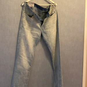 Ljusblå regular fit jeans &Denim - Säljer ett par ljusblå jeans från &Denim i regular fit. Klassisk femficksmodell med dragkedja och raka ben. Jeansen har en snygg tvättad look och är tillverkade i bomullsdenim. Perfekta för en avslappnad stil.