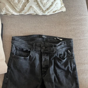 Svarta Replay Grover jeans - Säljer ett par svarta Replay Grover jeans i klassisk femficksmodell. Jeansen har raka ben, snygga detaljer på bakfickorna och diskret Replay-logga. Materialet är mjukt och stretchigt för extra komfort. Perfekta för dig som gillar stilrena och tidlösa jeans. STORLEK: 31,36