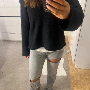 Grå ripped jeans från Gina Tricot - Säljer ett par grå jeans från Gina Tricot med stora slitningar över knäna. Jeansen har en rak passform. Perfekta för dig som gillar en avslappnad och trendig stil.
