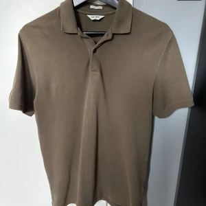 Grön pikétröja  - Säljer denna grön-bruna piké tröjan från East west i storlek small. Kontakta vid frågor!