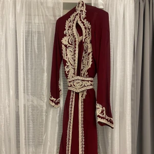 Röd kaftan - Säljer min fina röda kaftan som aldrig kom till användning. Köptes från en annan tjej på plick, små defekter på armen och längst ner av släpet av guldet/stenarna som fastnat. Annars mycket gott skick och önskas få ett annat hem med användbar användning.❤️