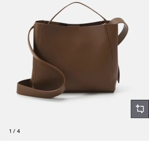 Brun handväska  - Brun midi bag från Ginatricot så är slutsåld!  Väldigt rymlig och snygg. Väskan har ett fack i mitten med en dragskedja som skärmar av väskan till två delar. Det tillkommer även ett lång band till🤩