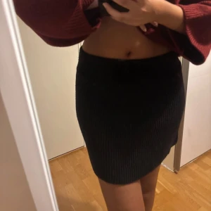 Svart stickad kjol  - Den har använts en del och är nopprig på vissa ställen!