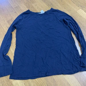 Mörkblå långärmad tröja La Redoute - En basic mörkblå långärmad tröja från La Redoute. Tillverkad i mjuk bomull med rund halsringning och diskret sömdetalj framtill. Perfekt att styla lager på lager eller bara som den är.