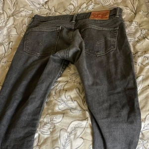 Grå Levi's 501 jeans straight fit - Säljer ett par grå Levi's 501 jeans med klassisk straight fit. Jeansen har fyra fickor, synliga sömmar och den ikoniska läderpatchen bak i midjan. Perfekta för dig som gillar en tidlös look och vill ha ett par jeans som funkar till allt. Dom är lågmidjade.