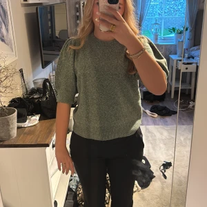 Grön stickad tröja från Vero Moda - Mysig grön stickad tröja från Vero Moda med korta puffärmar och ribbade muddar. Tröjan har en avslappnad passform och är perfekt för lager-på-lager. Snygg till både jeans och kostymbyxor.