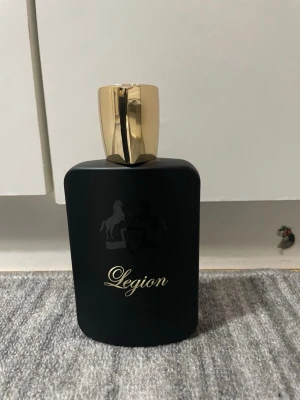 Legion Eau de Parfum 100ml - Legion Eau de Parfum från Fragrance World, 100ml. Snygg design med gulddetaljer och stilrent svart. Tillverkad i U.A.E. Helt full flaska. Finns i Göteborg att hämtas!