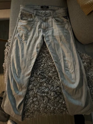 Replay ljusgrå jeans med raka ben - Snygga ljusgrå jeans från Replay med klassisk femficksdesign och raka ben. Jeansen har svarta kontrastsömmar och Replay-logga på fickan fram. Materialet är slitstarkt denim i bomull och passformen är normal. Perfekt för dig som gillar stilrena och tidlösa jeans. Storlek: W32 L34