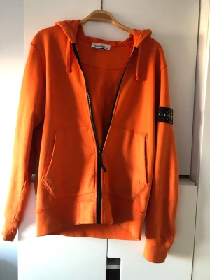 Stone Island Hoodie - Orange Stone Island Hoodie som är väldigt lite använd. Passar perfekt under vestar eller som plagg i sig med vit t-shirt under till exempel. 