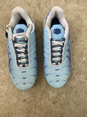 Nike Air Max Plus Tn blå sneakers - Säljer ett par Nike Air Max Plus Tn sneakers i ljusblå och marinblå färg med vita meshpaneler och snörning. Skorna har en unik sula med synlig Air-enhet och Tn Air-logga på hälen. Exklusiv Foot Locker-tag medföljer. Perfekt för dig som gillar statement sneakers.