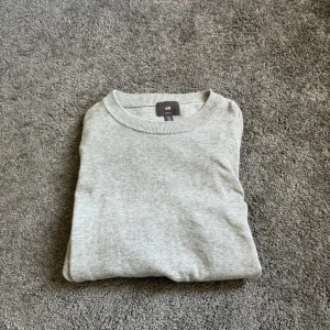 Grå crewneck stickad tröja  - Tjena, säljer nu min crewneck. Är 180 och den passar perfekt. Den är i väldigt bra skick och använd ett fåtal gånger. Hör av dig om du har fler frågor
