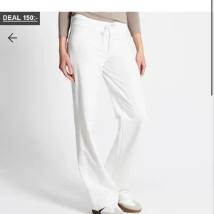 Vita mjukisbyxor med snörning - Säljer ett par vita mjukisbyxor med snörning i midjan. Byxorna har en loose passform och raka ben, perfekta för en chill och avslappnad stil. Materialet känns mjukt och bekvämt mot huden.