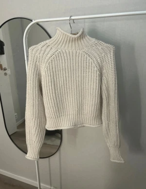 Vit stickad polotröja från H&M - Säljer en vit stickad polotröja från H&M i storlek XS. Tröjan har grov ribbstickning, hög polokrage och långa ärmar. Modellen är lite croppad och har en snygg, klassisk look som passar perfekt till till exempel jeans och smycken! Köpt av en tjej på vinted för 130 kr! Säljs då den inte passade mig men tröjan är ny utan prislapp!!🥰Djur och rökfritt hem, pris kan diskuteras!