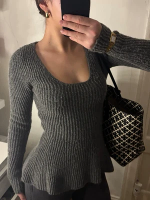 Grå ribbad stickad tröja - Säljer en grå stickad tröja med ribbad struktur och v-ringad hals. Tröjan har lång ärm och en figurnära passform. Den är lite nopprig som de flesta stickade kläder blir, men det går enkelt att ta bort med t.ex en rakhyvel. Den är ifrån h&m och är använd ett fåtal gånger. 