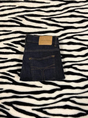 Tiger of Sweden - Snygga mörkblå jeans från Tiger of Sweden med klassisk femficksdesign och kontrastsömmar. Modellen har rak passform och dragkedja i gylfen. Perfekta för dig som gillar stilrena och tidlösa jeans med en modern touch. Hör av dig vid minsta fundering 🤙
