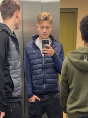 Mörkblå cardigan Calvin Klein M - Snygg mörkblå pufferjacka från Calvin Klein Golf med quiltad front och dragkedja. Jackan har långärmade partier i stickad polyester och en liten CK-logga på bröstet. Perfekt för dig som vill ha en sportig och modern look.